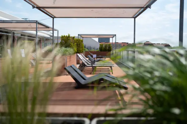 Foto von Liegestühlen und Sonnenschutz auf der Dachterrasse des Manhattan Clubs Wien