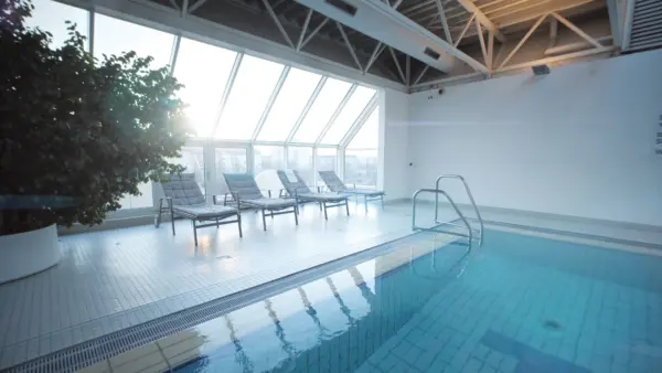 Pool im Dachgeschoss vom Manhattan Club Wien mit Panaorama Fenstern und Morgen Sonnenlicht