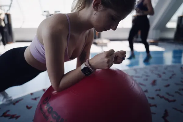 Young woman holding a plank with her arms supported on a stability ball at Manhattan Club Brunn
